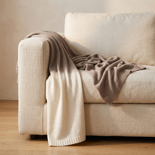 Toast Ombré 100% cashmere throw, draped over a sofa
