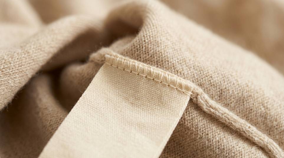 Blank woven label stitched into the inside seam of a cashmere knit garment