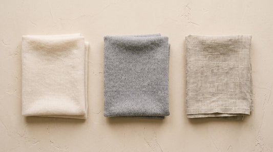 Three natural fibre swatches - cashmere, wool and linen - arranged for comparison