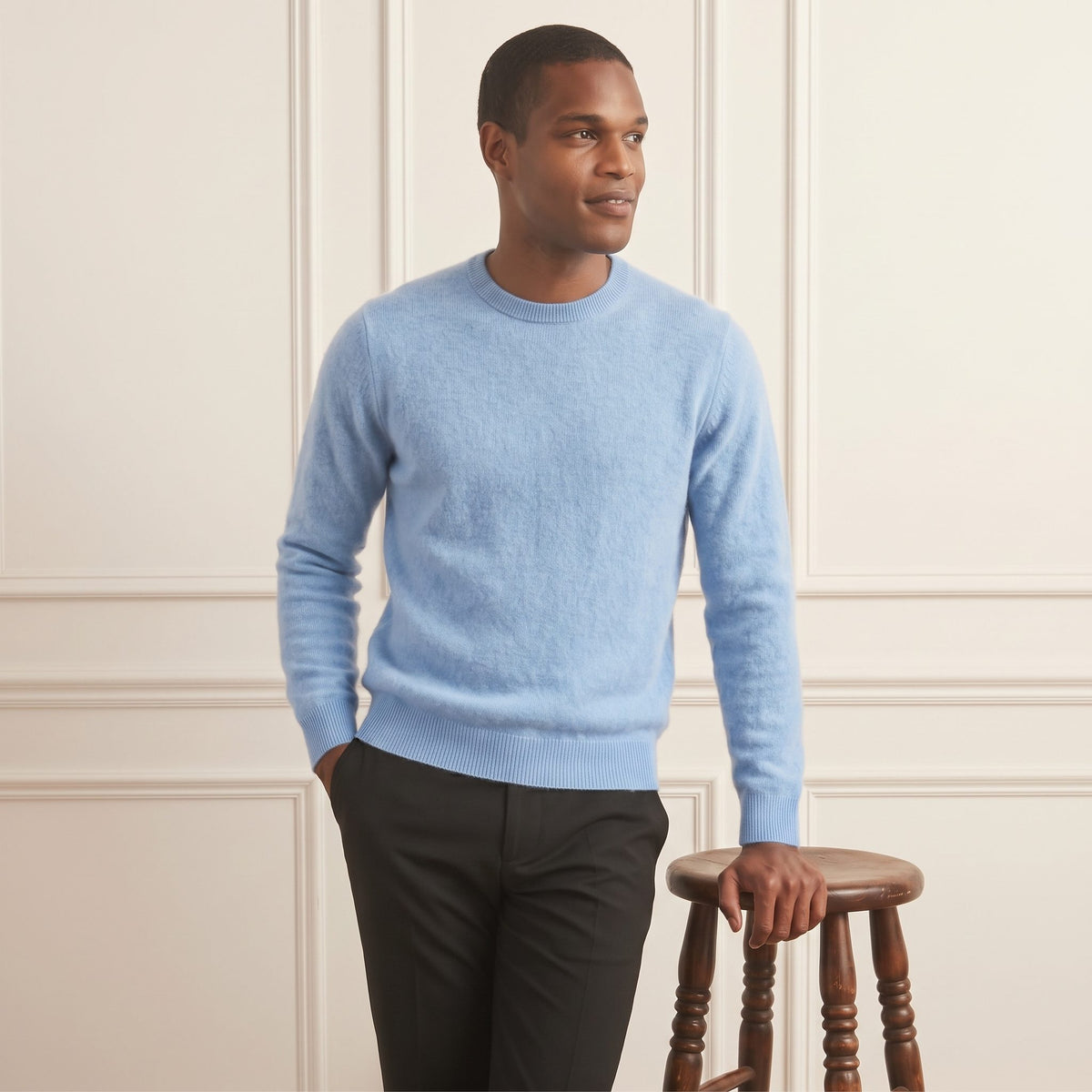 Sky blue men's 100% cashmere crewneck sweater - front view, standing beside stool