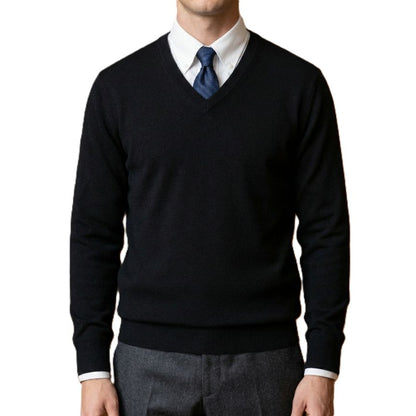 Person wearing a black sweater over a white shirt with a blue tie on a white background