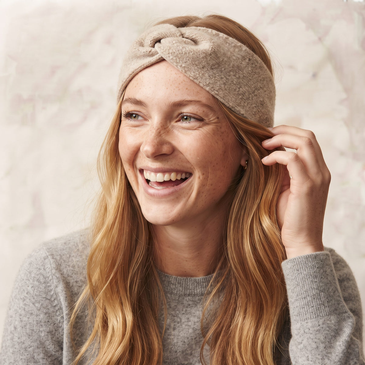Undyed Gomba twisted-front cashmere headband in Oatmeal Melange, worn, adjusting
