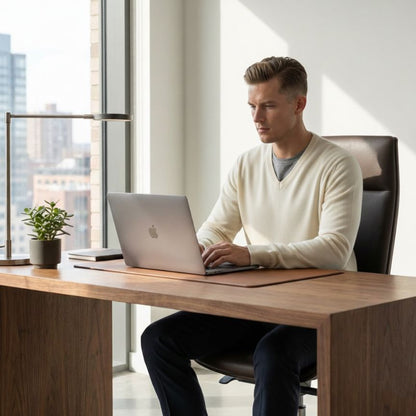 Man working on a laptop at a desk with a cityscape view