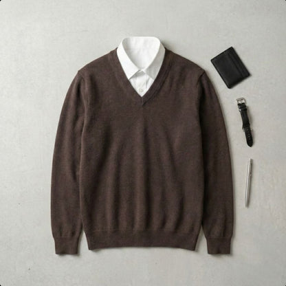 Brown sweater over a white shirt with a wallet, pen, and lighter on a gray background