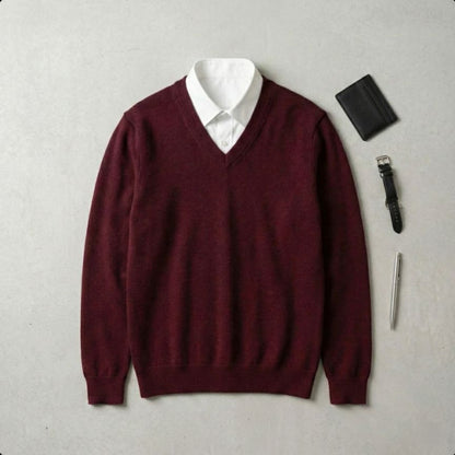 Maroon sweater over a white shirt with a black wallet and pen on a gray background