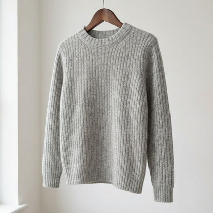 Gray ribbed sweater on a wooden hanger against a white background