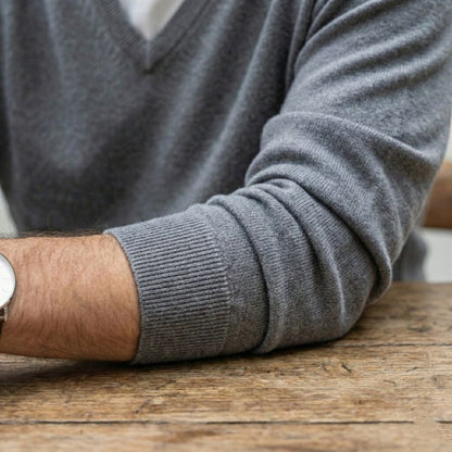 Person wearing a gray sweater with a blurred background