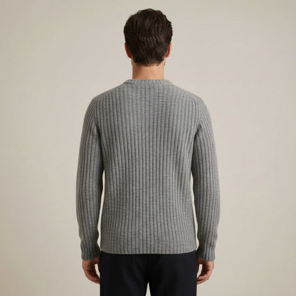Man wearing a gray ribbed sweater against a beige background
