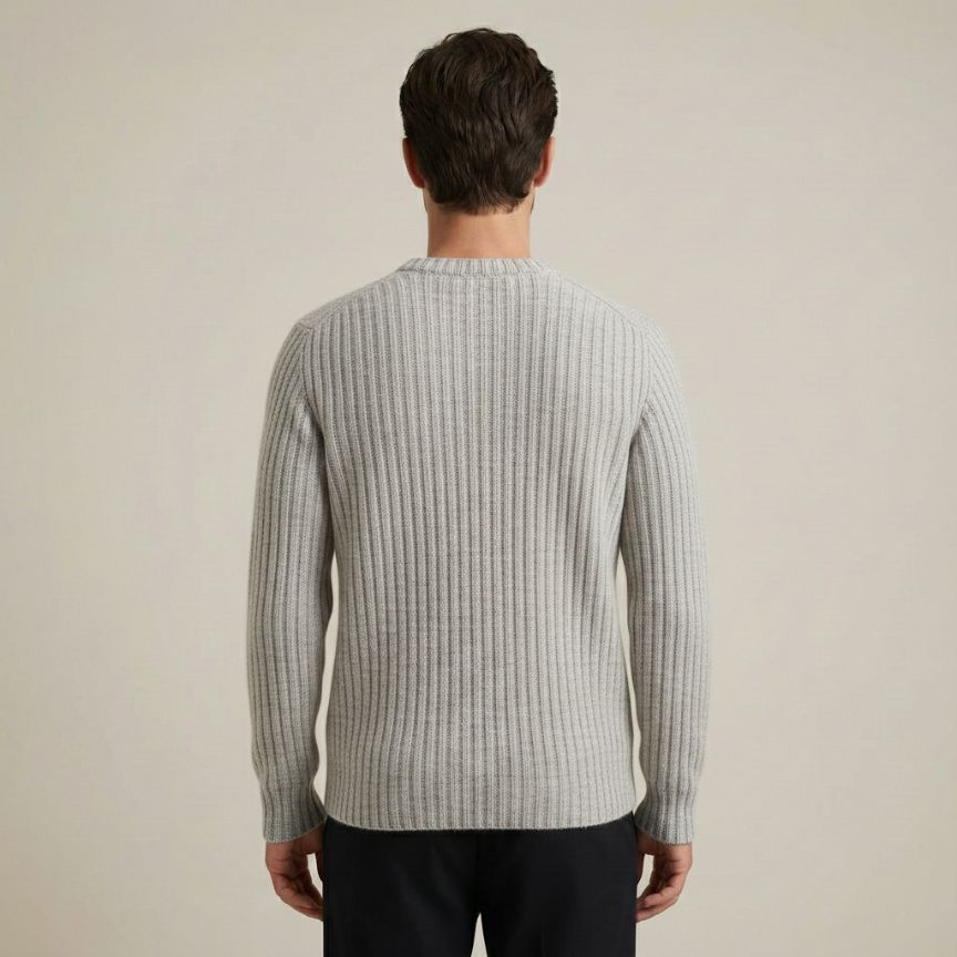 Man wearing a ribbed sweater against a plain background