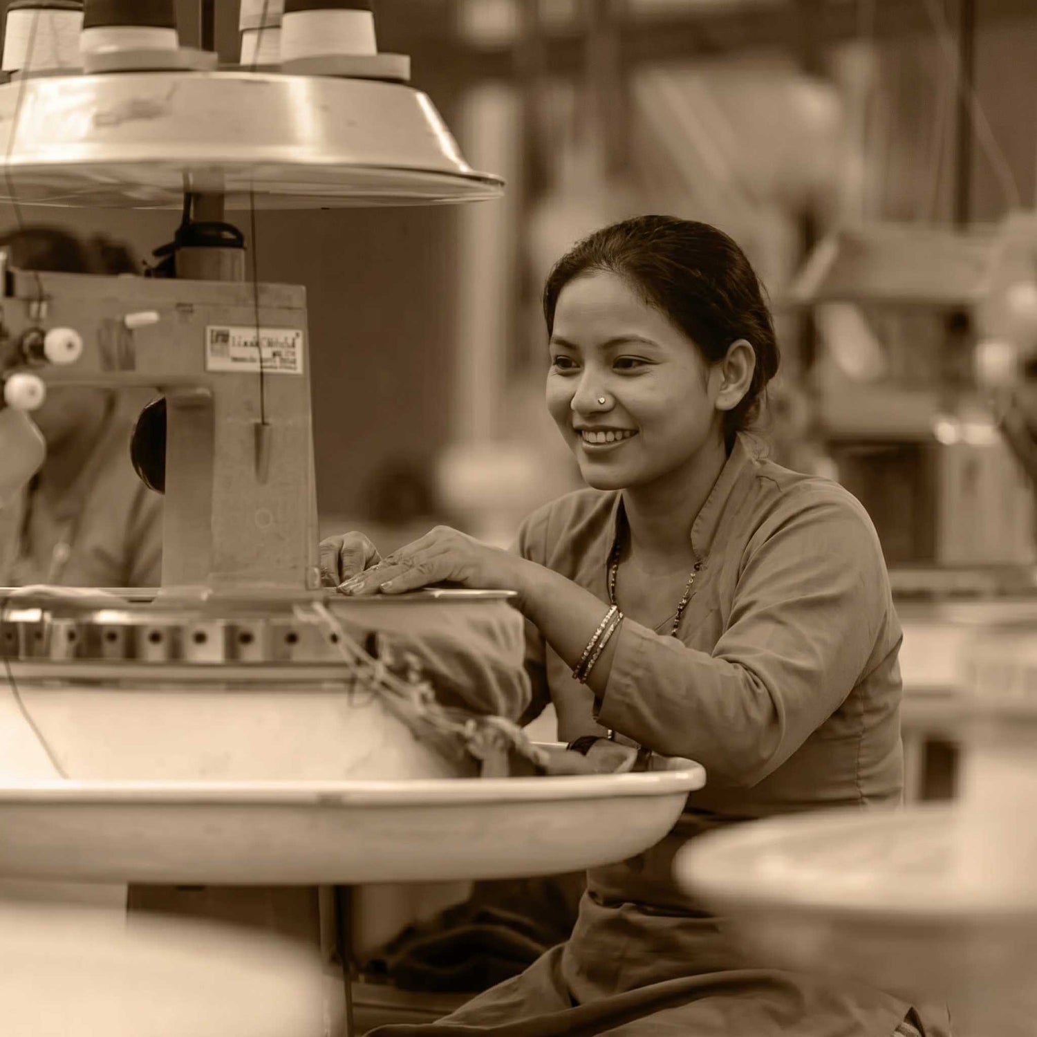 Woman working at a sewing machine in a factory setting