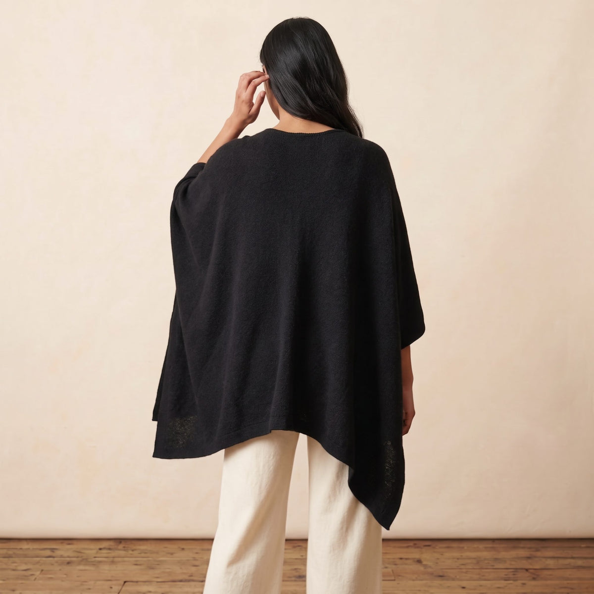 Women's V-neck cashmere poncho in Black — worn by a model (4)