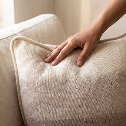 Toast Ombré 100% cashmere pillow cover, hand on the knit, showing softness