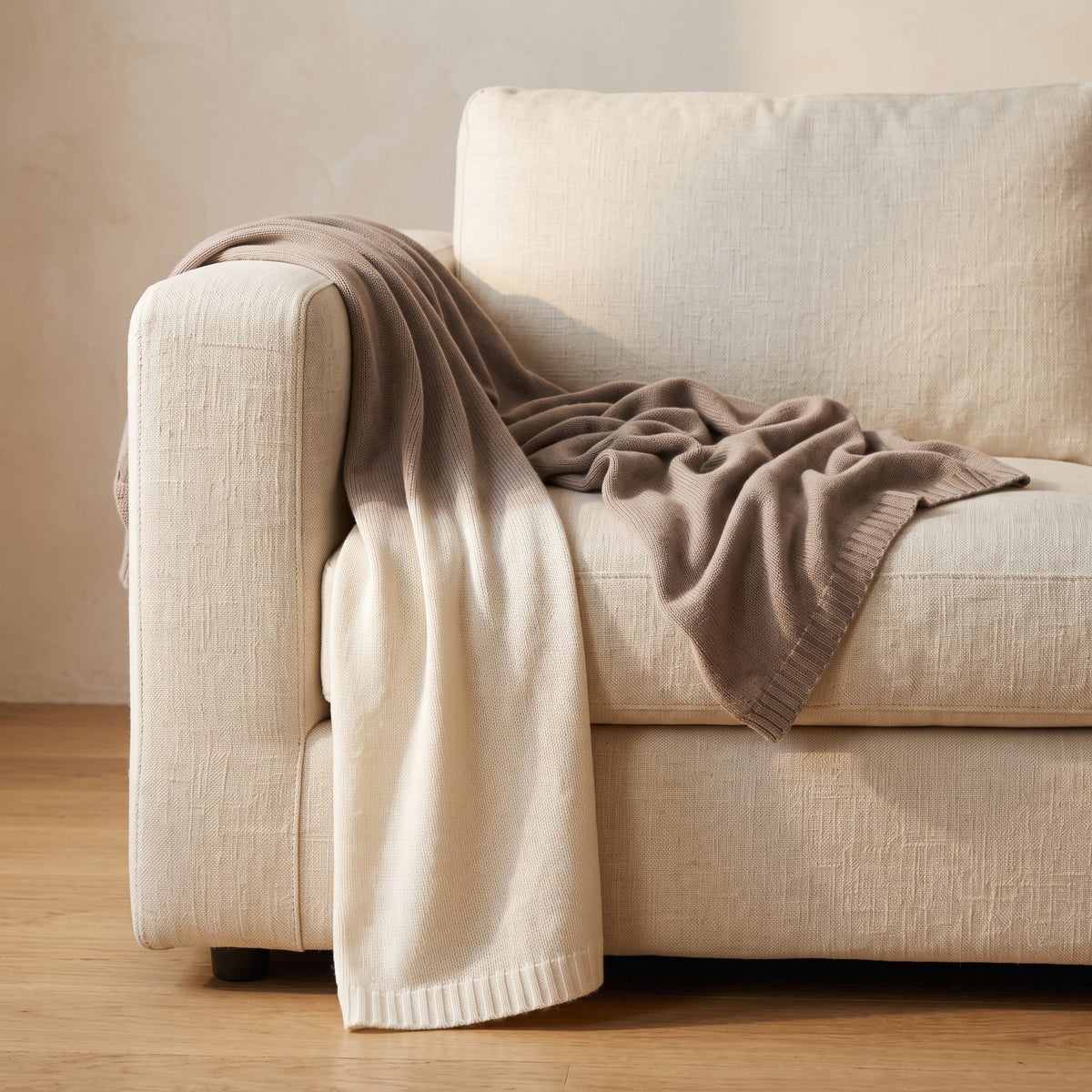 Toast Ombré 100% cashmere throw, draped over a sofa